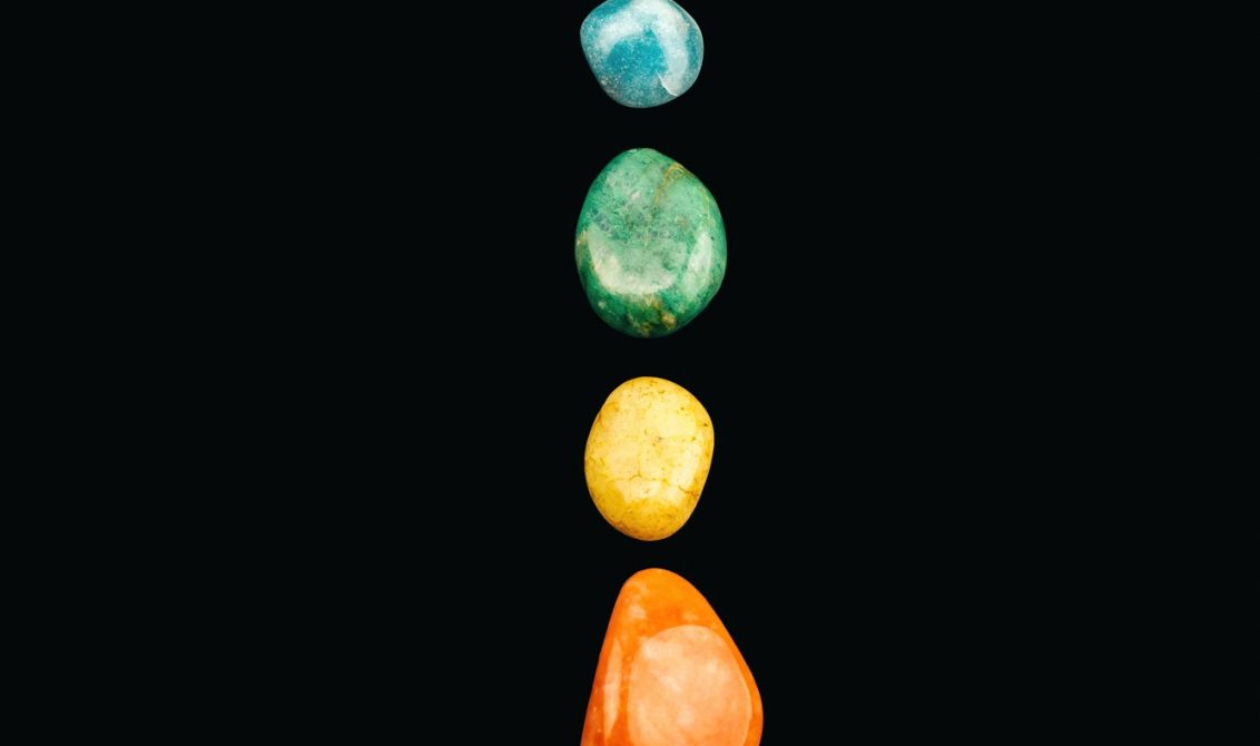 Chakra stones, crystals in a row on black background